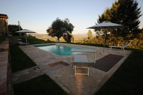 una piscina con tavolo e ombrellone di Azienda Agraria Montelujano a Gubbio