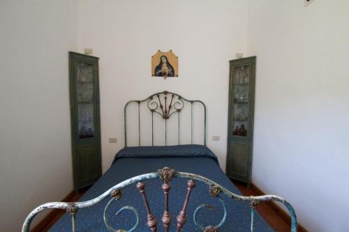 a bedroom with a bed with a blue comforter at La Locanda del Barbablù in Stromboli