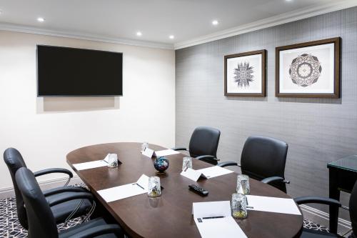 a conference room with a table and chairs and a television at Castle Hotel Windsor in Windsor