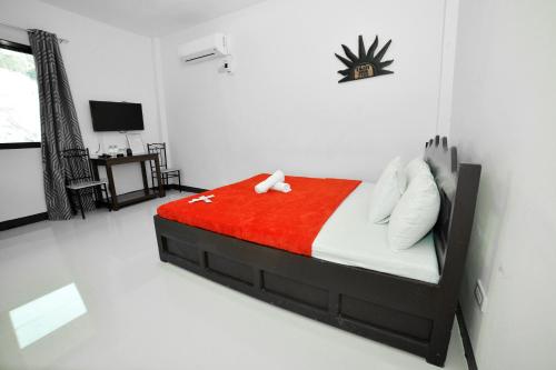 a bedroom with a bed with a red blanket at Sunrise Garden Lake Resort in Lahit