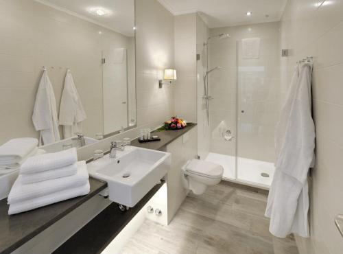 a bathroom with a sink and a toilet and a shower at Hotel Max am Meer Kühlungsborn in Kühlungsborn