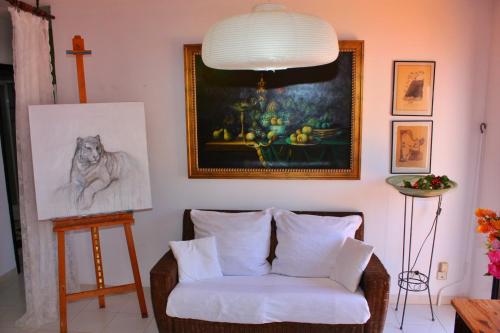 a living room with a chair and a painting at Cura Sol in Playa del Cura