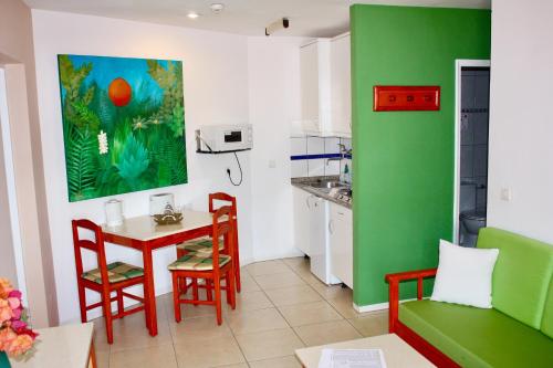 a kitchen with a table and a green wall at Cura Sol in Playa del Cura