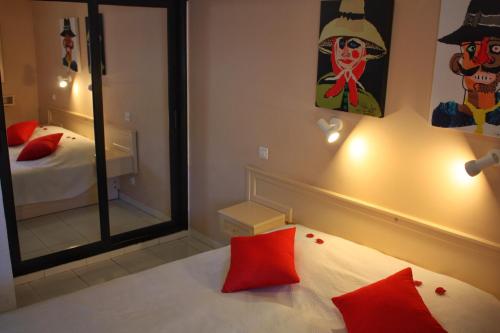 a bedroom with a mirror and a bed with red pillows at Cura Sol in Playa del Cura