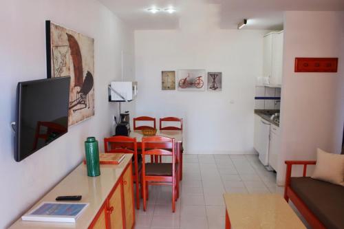 a living room with a table and chairs and a kitchen at Cura Sol in Playa del Cura