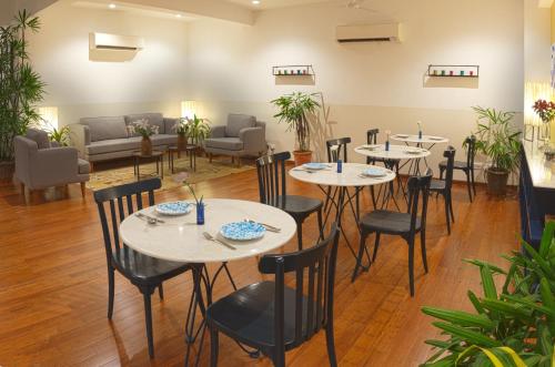 a restaurant with tables and chairs in a room at Bungalow 99 in New Delhi