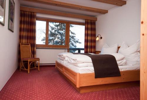ein Schlafzimmer mit einem großen Bett und einem Fenster in der Unterkunft Appartementhaus Leitner in Ehrwald