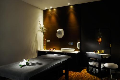 a black room with a bed and a sink at Hotel Thermana Park Laško**** Superior in Laško