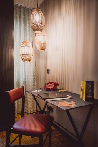 a table with a chair and some lights at Henri Hotel Düsseldorf Downtown in Düsseldorf