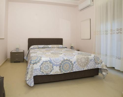 a bedroom with a bed with a blue and white quilt at Casa Nonna Elvira in Roccalumera