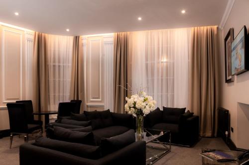 a living room with couches and a vase of flowers at The County Aparthotel in Newcastle upon Tyne