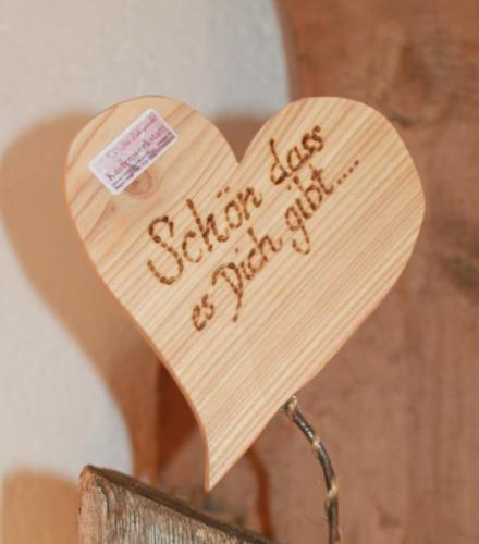 a wooden heart with a sign that says school less school stuff at Ferienwohnungen Bachergut in Mariapfarr