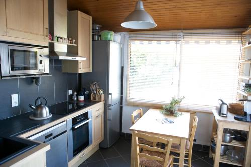 une cuisine avec une petite table et une cuisine avec une fenêtre dans l'établissement Villa Dumont D'urville, à La Turballe