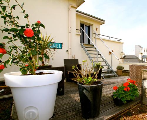 a patio with two potted plants on a deck at Urban Style hotel de l'Europe in Rouen