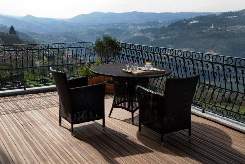 a table and chairs on a deck with a view at Casa Altamira in Espadanedo