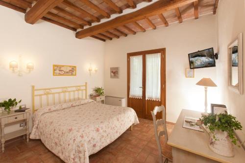 a bedroom with a bed and a desk and a table at Bio Agriturismo Le Cascatelle in Saturnia