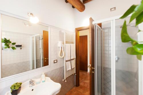 a bathroom with a sink and a mirror and a shower at Agriturismo Le Cascatelle in Saturnia