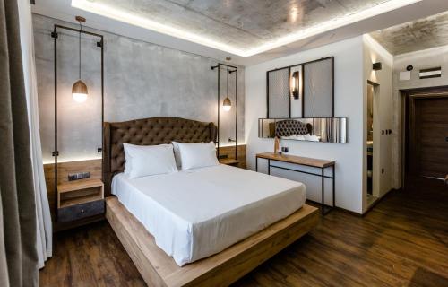 a bedroom with a large white bed and a table at HOTEL FINIX CASINO in Kulata