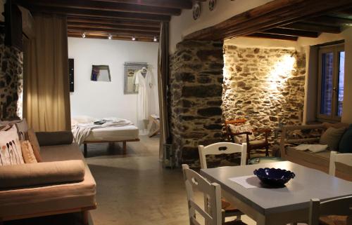 a living room with a table and a stone wall at Alitanes in Áno Meriá
