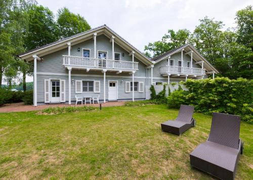 a house with two chairs on a yard at Hotel Gut Klostermühle natur resort & medical spa in Alt Madlitz