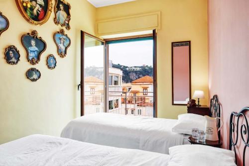 a bedroom with two beds and a window with a view at La Musica in the Heart of Sorrento, 100 m from Station in Sorrento