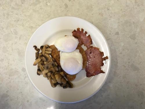 a plate of food with eggs and mushrooms on it at Hawthorn House Hotel in Kettering