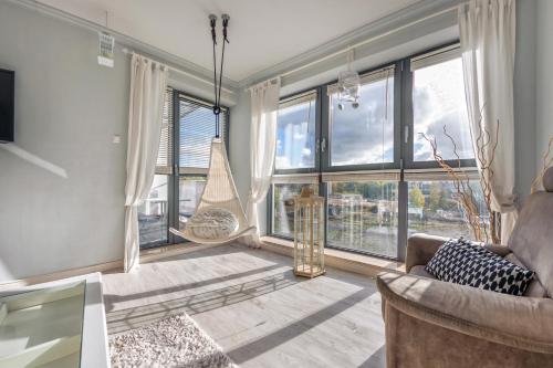 a living room with large windows and a couch at Apartamenty Sun & Snow Międzyzdrojski Rynek in Międzyzdroje