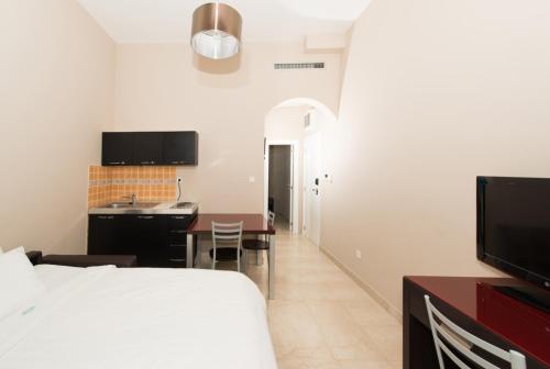 a bedroom with a bed and a kitchen with a table at Apartments Grifone Lux in Herceg-Novi