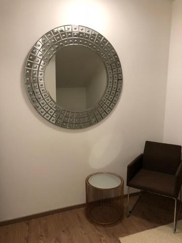 a mirror on a wall next to a chair at Appartement am Berg in Ebene Reichenau