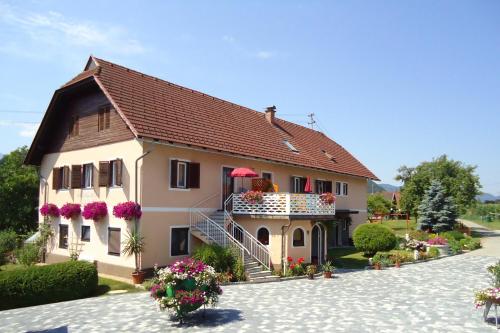 a house with a balcony and flowers on it at Erlebnisbauernhof Tschom in Sankt Kanzian