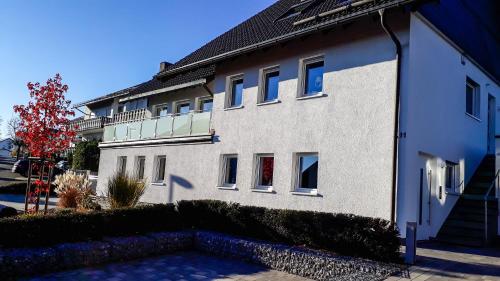 a white building with a balcony on the side of it at Apartment Schanzenstraße 690 m ü. M in Winterberg