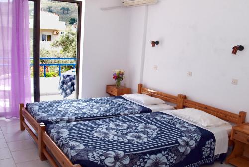 a bedroom with two beds and a balcony at Rosmari Hotel in Archangelos