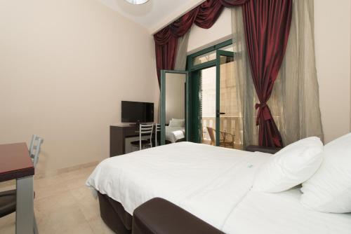 a bedroom with a white bed and a window at Apartments Grifone Lux in Herceg-Novi