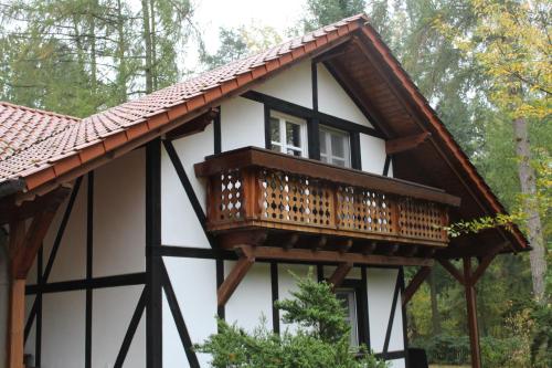 a house with a balcony on top of it at Hotel Gut Klostermühle natur resort & medical spa in Alt Madlitz