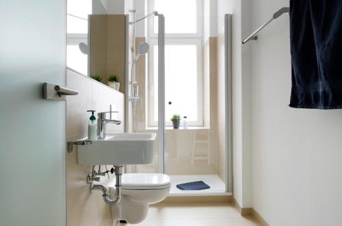 a bathroom with a toilet and a sink and a shower at Apartment KATZBACH - Cozy Family & Business Flair welcomes you - Rockchair Apartments in Berlin