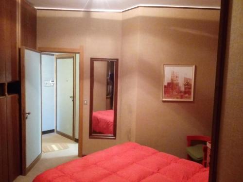 a bedroom with a red bed and a mirror at bilocale Giomein in Breuil-Cervinia
