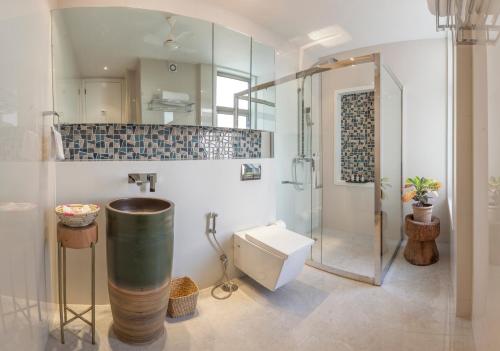 a bathroom with a shower and a toilet and a sink at Bungalow 99 in New Delhi