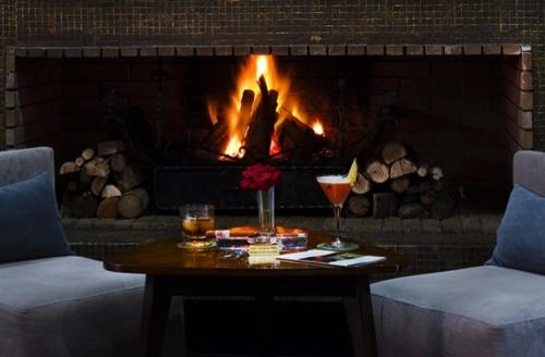 a fireplace with a table in front of it with a fire at Le Sphinx Boutique Hôtel in Mohammedia