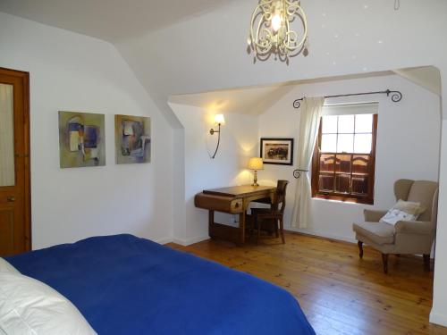 um quarto com uma cama, uma secretária e uma janela em The Gables em Hout Bay