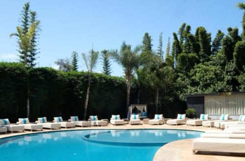a swimming pool with lounge chairs and a group at Le Sphinx Boutique Hôtel in Mohammedia