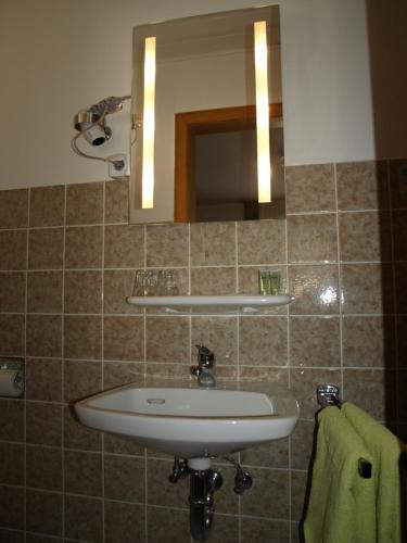 La salle de bains est pourvue d'un lavabo et d'un miroir. dans l'établissement Bed&Breakfast Eifelpension Brückenschenke, à Fuchshofen