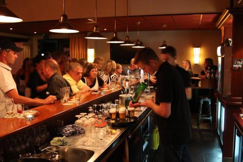 un grupo de personas sentadas en un bar en un restaurante en Friesland-cottage, en Molkwerum