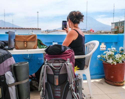 a woman taking a picture of a table with a backpack at El Albergue Español in Arequipa