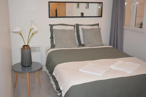 シャトー・ティエリにあるAppart Royal Couesnonのベッドルーム1室(ベッド1台、テーブルの上に花瓶1枚付)