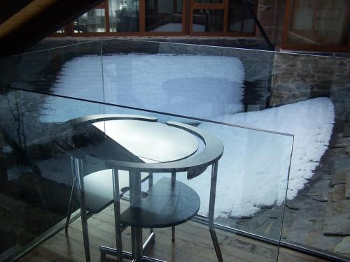 a glass table and a stool with snow on it at Alojamiento Luz de Hadas in Sampil