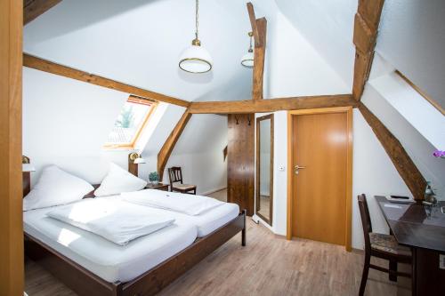 a bedroom with a bed and a desk in a room at Hotel Ratskeller in Nideggen
