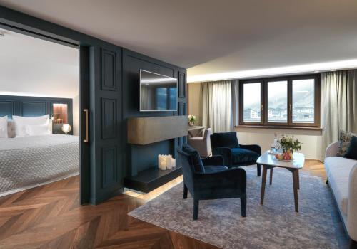 a hotel room with a bed and a living room at Hotel Zürserhof in Zürs am Arlberg