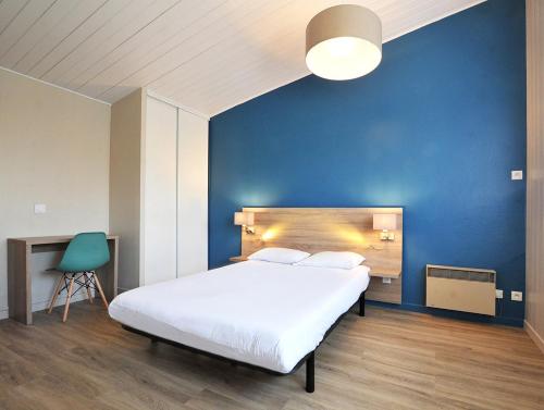 ein Schlafzimmer mit einem weißen Bett und einer blauen Wand in der Unterkunft Azureva Hauteville in Hauteville-sur-Mer