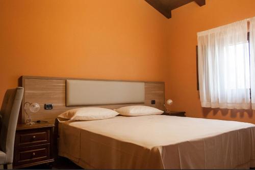 - une chambre avec un grand lit et une fenêtre dans l'établissement Feudo delle Querce, à Vena
