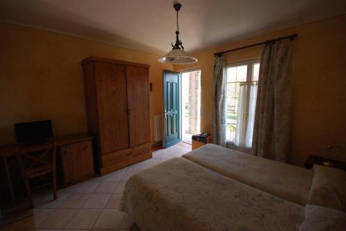 a bedroom with a bed and a tv and a window at Garni Viggiona in Trarego
